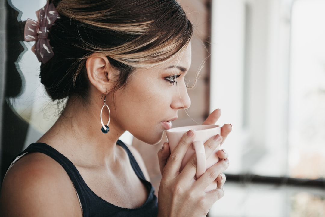 Person relaxing with a warm herbal drink using cramp bark for menstrual cramps