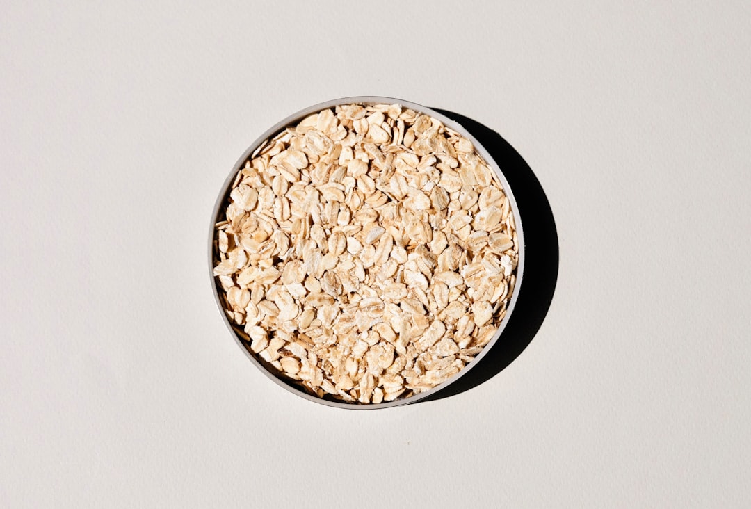 Oats in a ceramic bowl, the plant behind oatstraw for nervous exhaustion