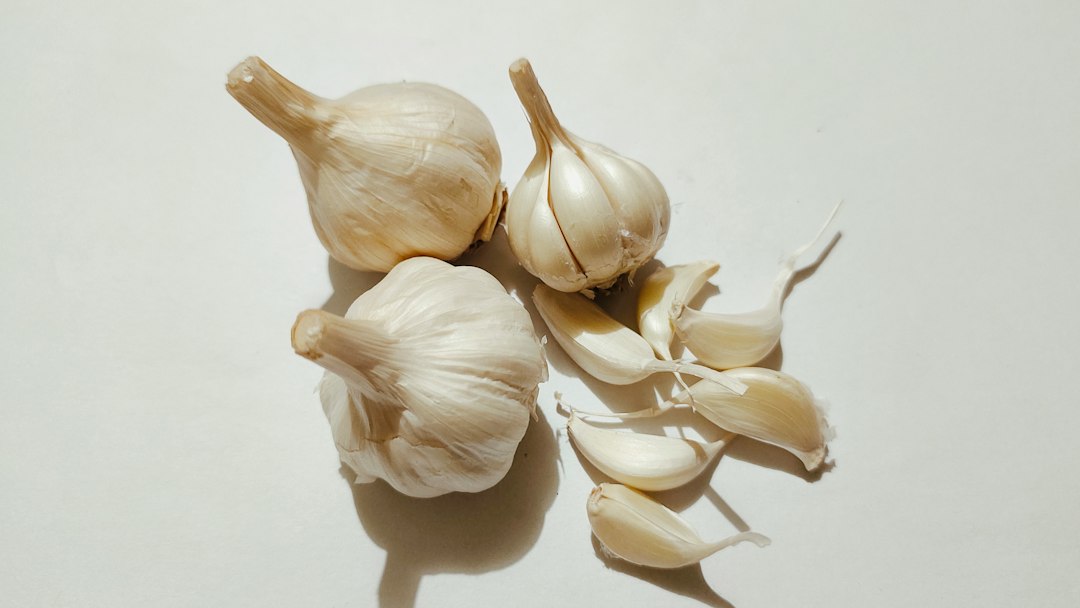 Whole garlic bulbs and loose cloves on a white table